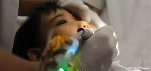 Une dentiste utilise une foreuse dentaire qui joue de la musique pour détendre les jeunes patients