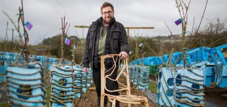 Un designer fait pousser des chaises dans un champ