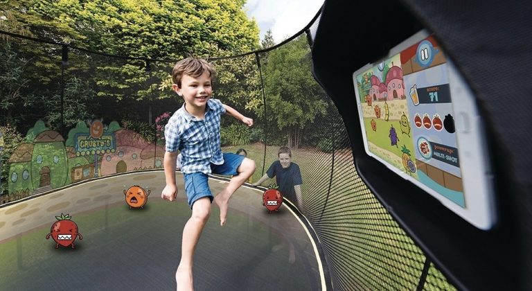 Les enfants jouent à des jeux sur tablette en utilisant un trampoline