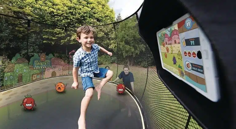 Les enfants jouent à des jeux sur tablette en utilisant un trampoline