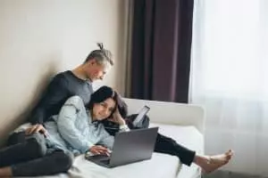 Les grands changements dans le monde des loisirs Couple Sitting on The Bed Working