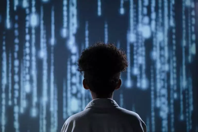 Quelles sont les innovations que l’intelligence artificielle peut apporter dans le casino en ligne en 2025? A young boy viewing a digital screen with data streams, symbolizing technology interaction.