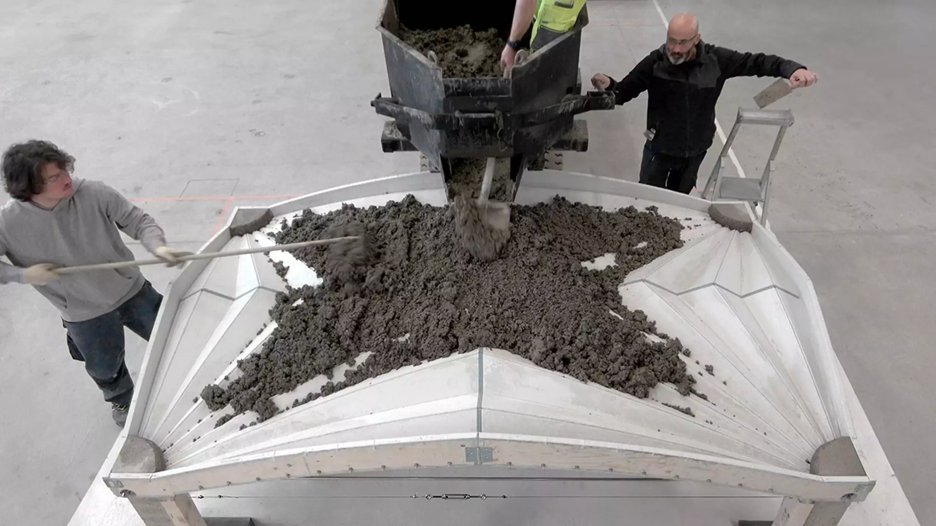 Le mélange de béton humide est versé dans le cadre Unfold Form pour durcir et former un sol voûté