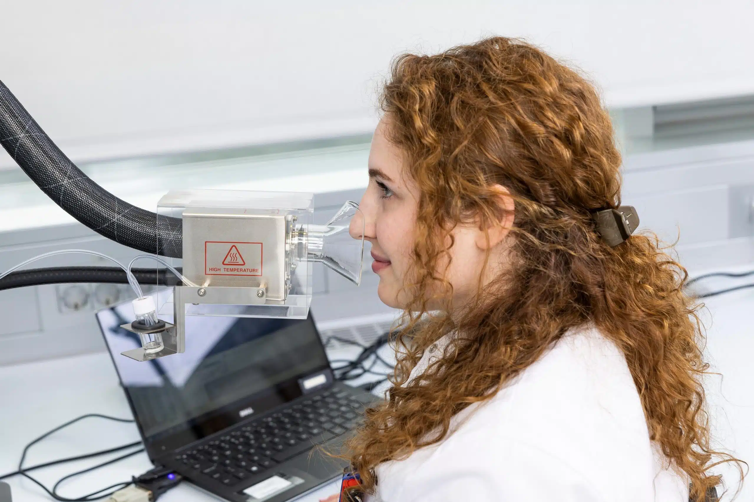 La chercheuse Emma Paolin hume un échantillon provenant d'un port olfactif d'un chromatographe en phase gazeuse-spectromètre de masse
