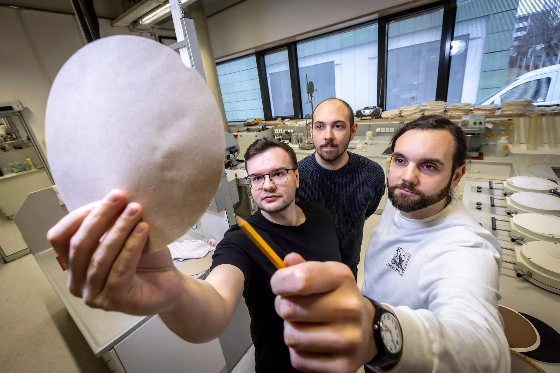 De gauche à droite, les chercheurs Alexander Weissensteiner, Alexander Wagner et Thomas Harter présentent un échantillon de papier composé à 30% de fibres de coton recyclées