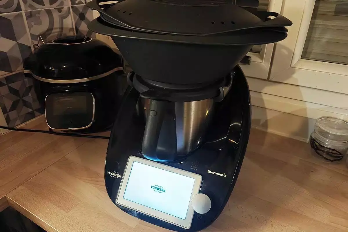 Un Thermomix est posé sur le comptoir de la cuisine.