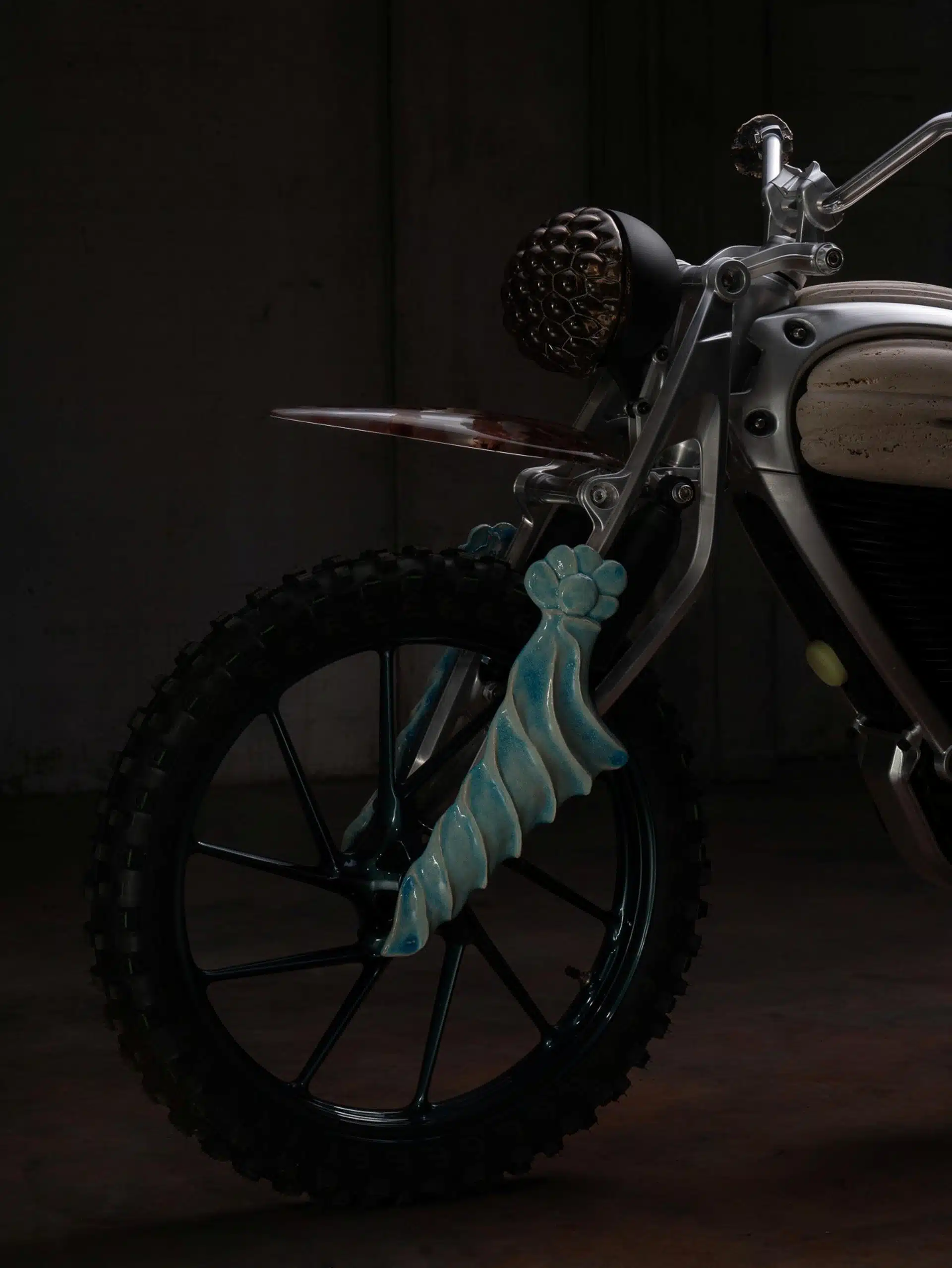 Les fourches en parallélogramme, qui rappellent les protections de fourche des motos scrambler, sont ornées de détails en argile façonnés à la main.