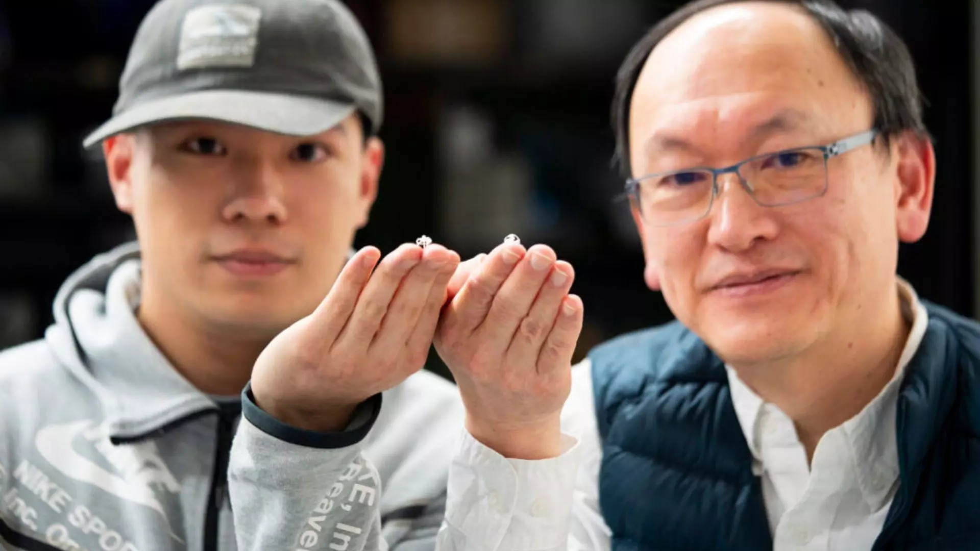 L'étudiant diplômé de l'université de Berkeley, Wei Yue (à gauche), et le professeur d'ingénierie Liwei Lin tiennent chacun un de ces minuscules robots dans leurs mains.