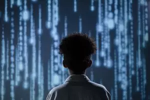 5 industries inattendues où l’IA est déjà utilisée en 2025 A young boy viewing a digital screen with data streams, symbolizing technology interaction.