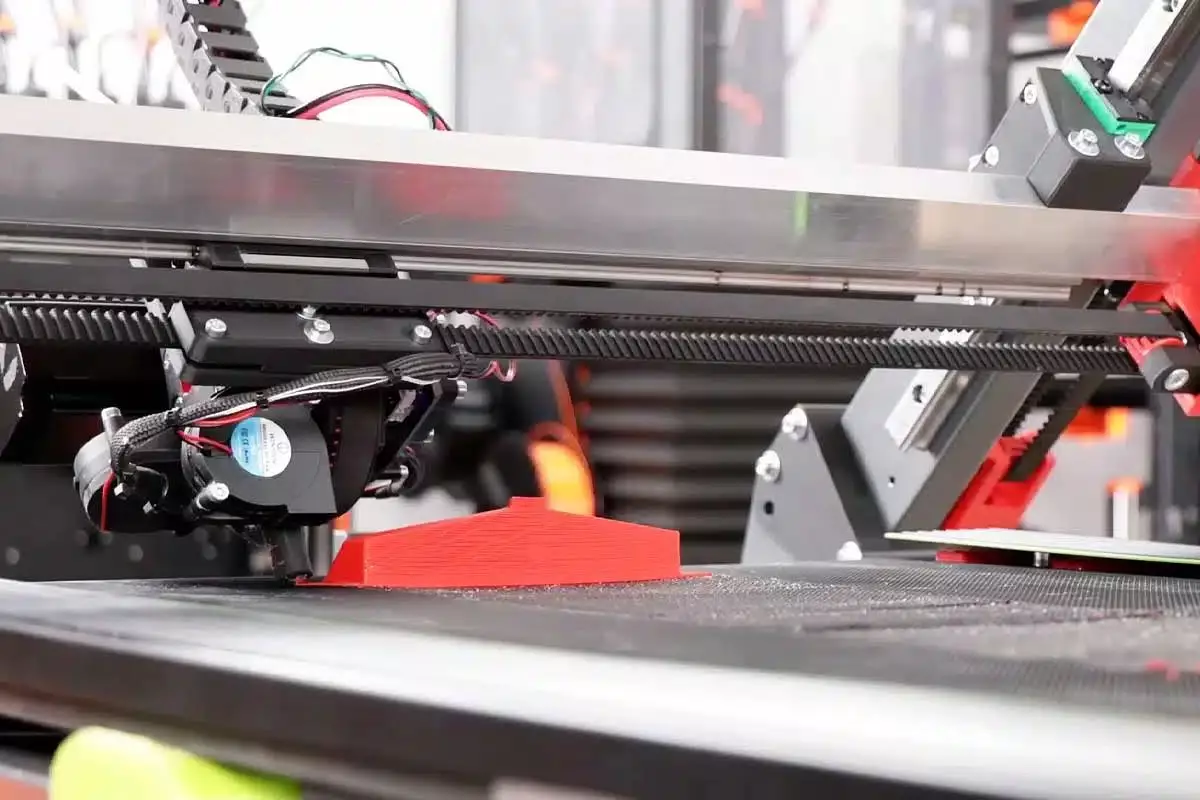 Une imprimante 3D à axe unique et dotée d'un tapis roulant.
