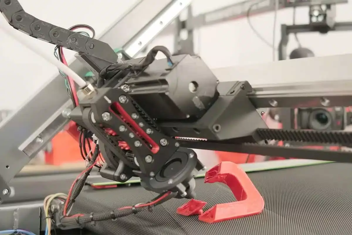Zoom sur l'imprimante 3D attachée au tapis roulant.