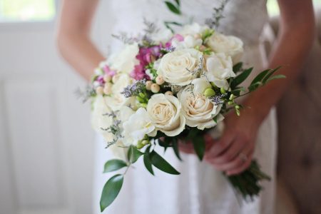 A beautiful bridal bouquet featuring white and pink roses, perfect for a wedding ceremony.