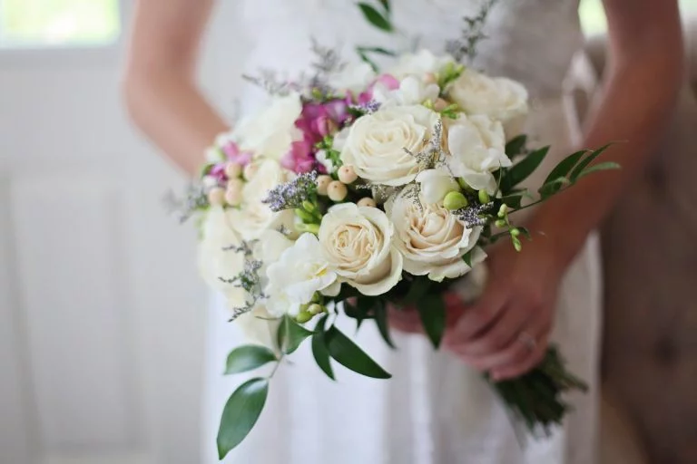 Panorama du marché des robes de mariée en France : tendances, défis et acteurs clés de l’industrie A beautiful bridal bouquet featuring white and pink roses, perfect for a wedding ceremony.