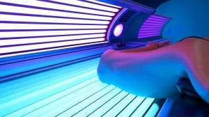 Les cabines de bronzage : un danger méconnu qui triple le risque de mélanome et endommage l’ADN Illustration de l'impact des cabines de bronzage sur l'ADN et le risque accru de mélanome.