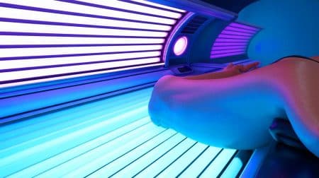Illustration de l'impact des cabines de bronzage sur l'ADN et le risque accru de mélanome.