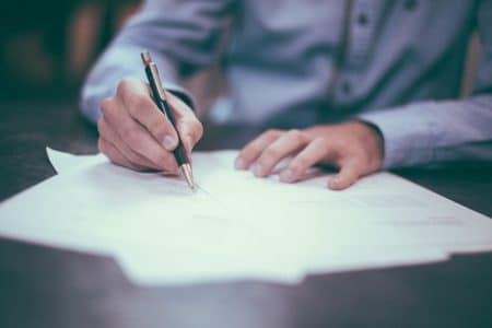TF1–M6 : le retour d’un projet de concentration aux lourdes menaces pour le pluralisme man writing on paper