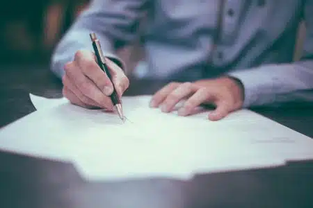 TF1–M6 : le retour d’un projet de concentration aux lourdes menaces pour le pluralisme man writing on paper